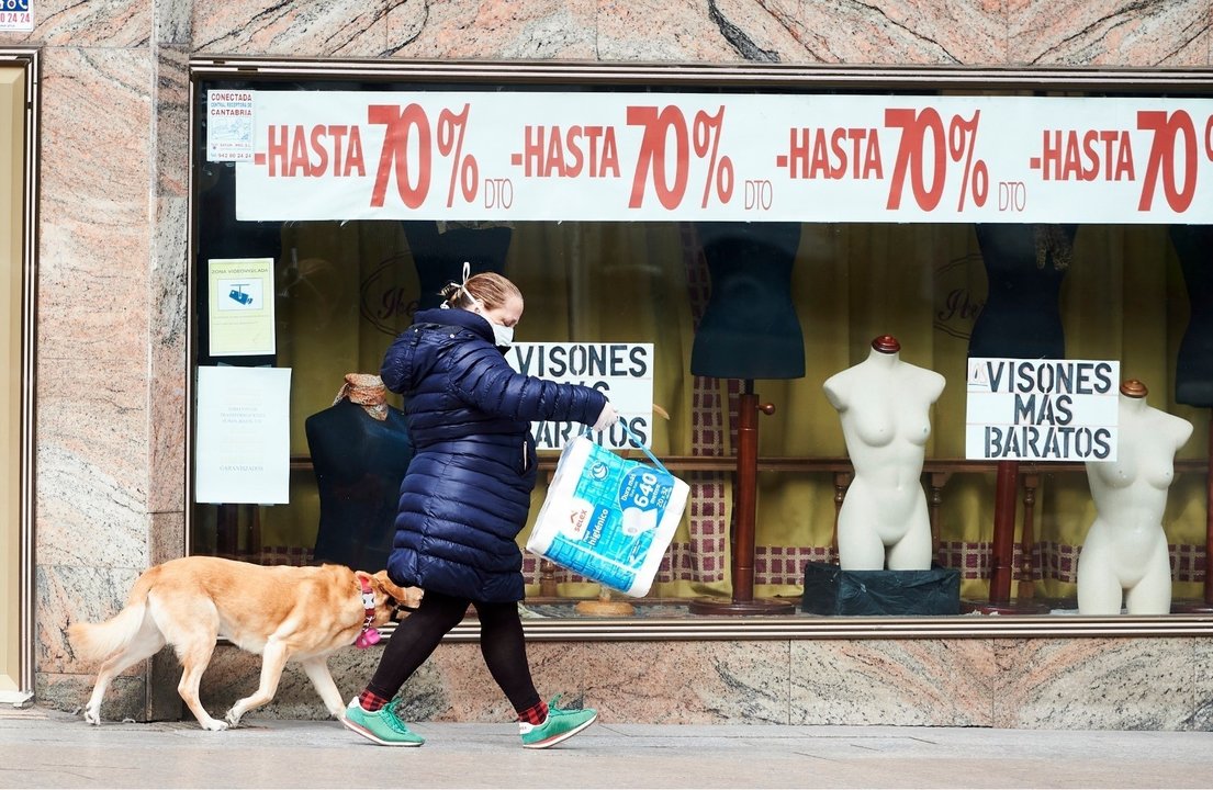 Mujer junto a un comercio cerrado