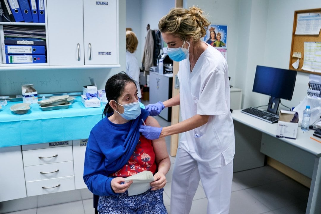 Una sanitaria vacuna a una mujer sin hogar en el Centro de Acogida Municipal Para Personas Sin Hogar San Isidro, a 20 de mayo de 2021, en Madrid (España). La visita coincide con el inicio de la vacunación para personas sin hogar en los centros municipales